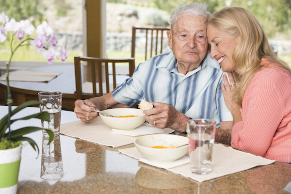 Senior man and adult daughter enjoing time together over lunch