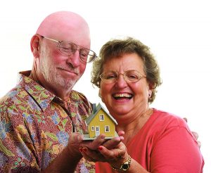 Happy Senior Couple holding a model home