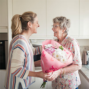 caregiver handing flowers to client