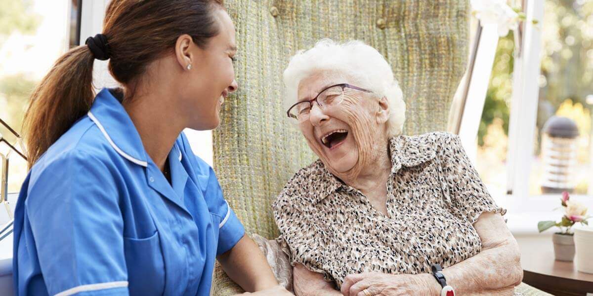 Caregiver laughing with senior client
