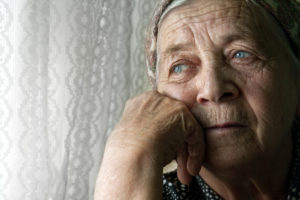 Sad elder woman looking out the window