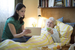 caregiver and senior lady looking at tablet