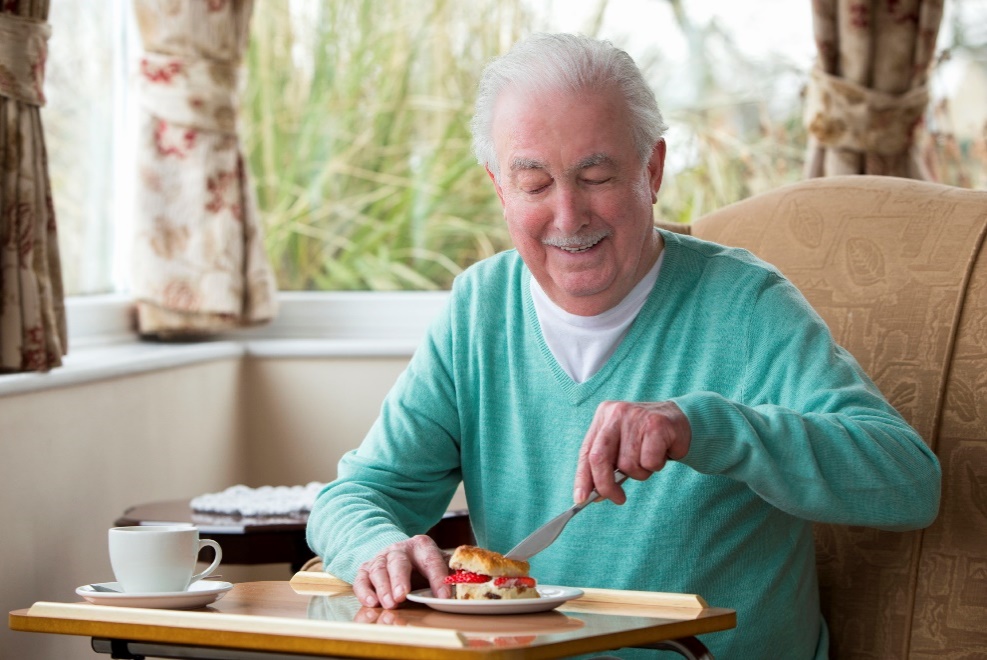 Happy senior man eating breakfast