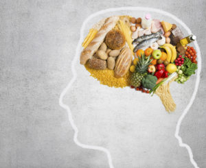Healthy foods that help prevent cognitive damage in seniors fill the brain of an outlined head.