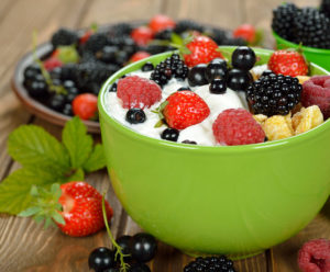 One of the top dietary tips for lung disease is eating a healthy breakfast, represented by a bowl of berries and yogurt.