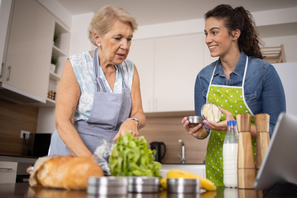 A woman receiving in-home diabetes care for seniors works with her caregiver to prepare a healthy meal.