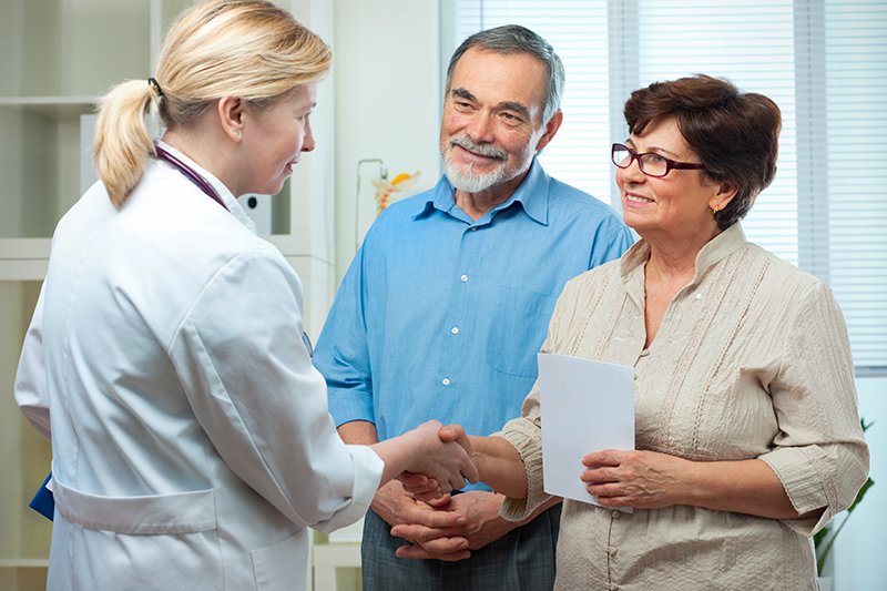 A woman who is advocating for a senior loved one shakes the hand of his doctor.