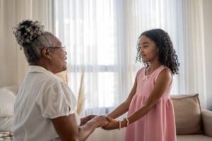 A young girl and her grandmother enjoy age-based caregiving activities.