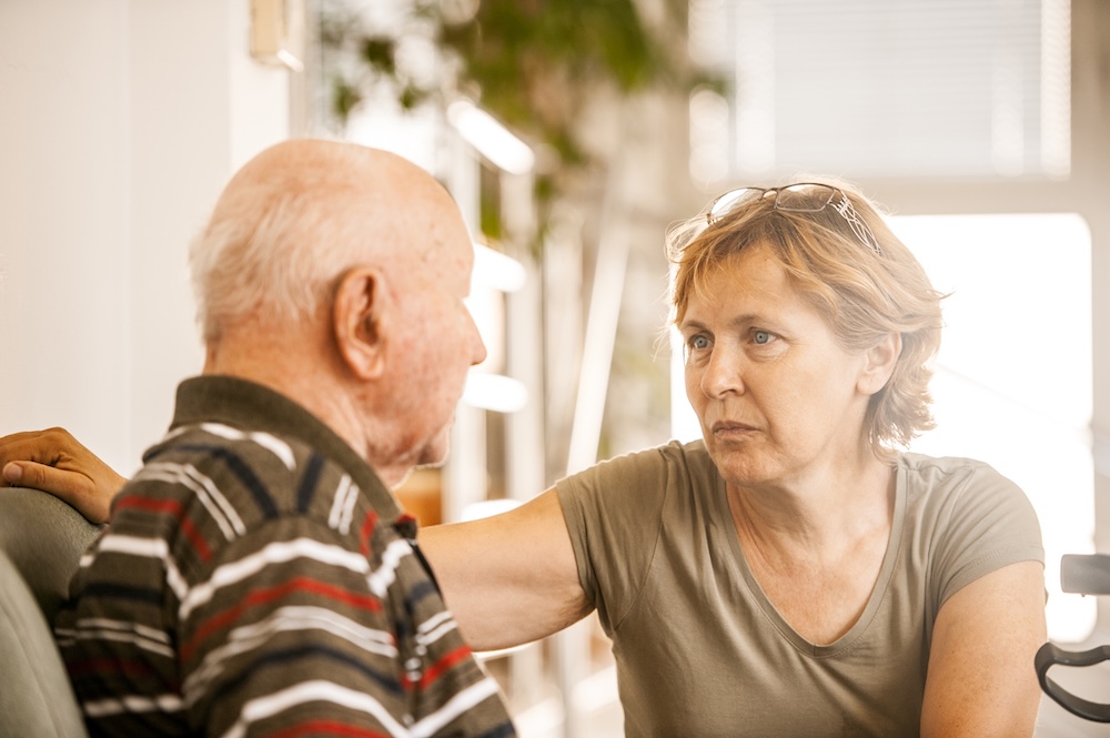 A woman noticing changes in caring for an older loved one talks earnestly with her father.