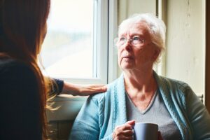 A woman who understands the mistakes to avoid when caring for aging parents comforts her elderly mother.