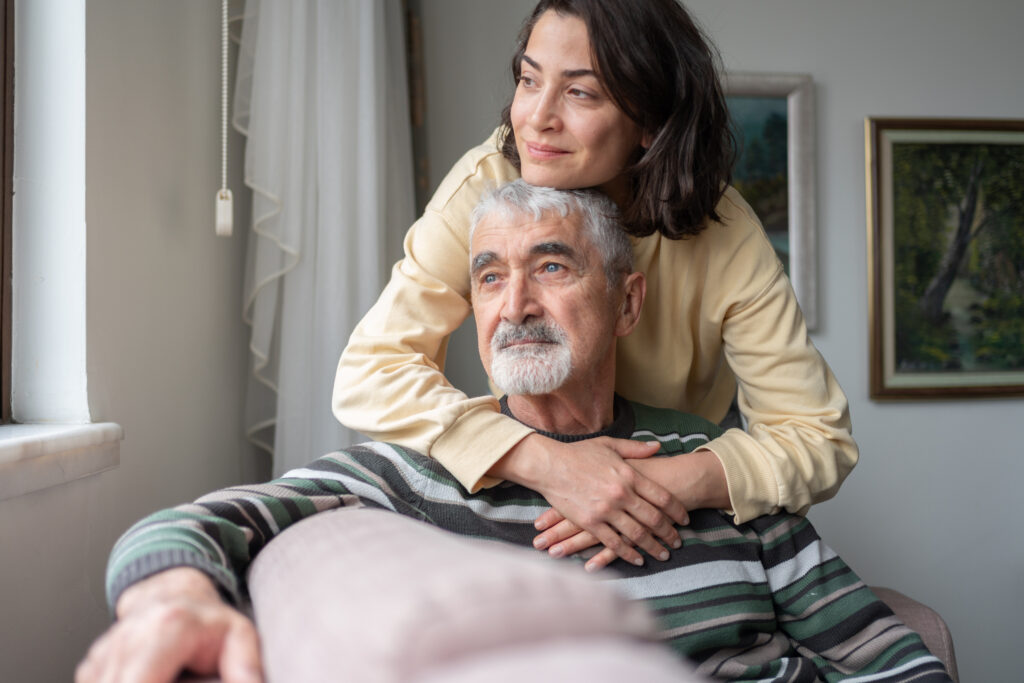 A woman hugs her dad as they consider adding home care in a nursing home.