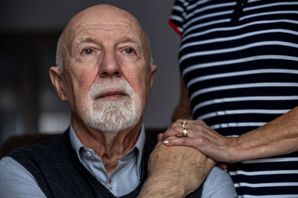 A man struggling with loneliness after being diagnosed with cancer is comforted by his caregiver.