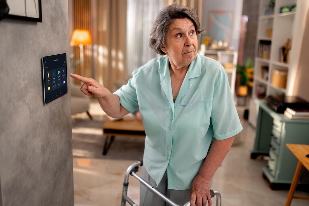 A woman points to a monitoring panel to express her concern about senior privacy.